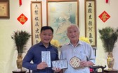 鄔有發書法家（右）向華人文化收藏家麒麟贈送作品。