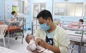 一名年輕爸爸在醫院病房給寶寶餵奶