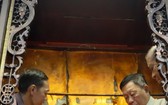 二府會館副理事長謝忠成（右）和諸位代表為神像更換袍冠。