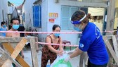 Tình nguyện viên đến trao nhu yếu phẩm từ "Chợ Nghĩa Tình"