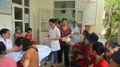 People wait for their turn for free examination (Photo: SGGP)