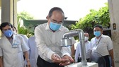Secretary of the Ho Chi Minh City Party Committee Nguyen Thien Nhan washes his hand at automatic hand sanitizer dispenser at Thong Nhat Hospital (Photo: SGGP)
