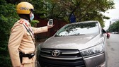 The police officer takes photos as an evidence of an illegally parking car (Photo: SGGP)
