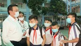 Director of the Ho Chi Minh City Department of Education and Training Le Hong Son talks to students in the first day of coming back schools (Photo: SGGP)