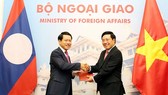 Vietnamese Minister of Foreign Affairs Pham Binh Minh and Lao Foreign Affairs Minister Saleumxay Kommasith exchange a protocol about the borderline and national border markers, an agreement on Vietnam-Laos border and border gate management regulations. (P