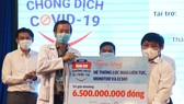 Ông Lê Thế Chữ, Tổng biên tập báo Tuổi Trẻ TPHCM trao bảng tượng trưng món quà bạn đọc báo gửi tới Bệnh viện Bệnh Nhiệt đới TPHCM Ảnh: DUYÊN PHAN