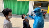 Nhân viên y tế lấy mẫu xét nghiệm cho người dân ở khu vực đường Cao Thắng, phường 17, quận Phú Nhuận, TPHCM. Ảnh: CAO THĂNG
