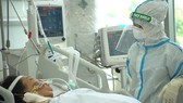 Bác sĩ chăm sóc bệnh nhân nặng tại bệnh viện dã chiến điều trị Covid-19. Ảnh: HOÀNG HÙNG