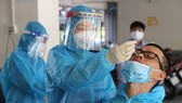 Nhân viên y tế lấy mẫu xét nghiệm cho người dân