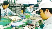 Workers making telecoms equipment at a plant of Viettel, a state-owned enterprise operated by the Ministry of Defense (Photo: SGGP)