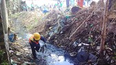 A worker collects garbage at a canal in HCMC (Photo: SGGP)