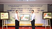 Bộ trưởng Bộ Thông tin và Truyền thông Nguyễn Mạnh Hùng (phải) tặng bức tem cho Trưởng Ban Tuyên giáo Trung ương Võ Văn Thưởng. Ảnh: TTXVN