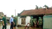 Lực lượng chức năng giúp người dân lợp lại mái nhà sau lốc xoáy ở xã Xuân Phổ, huyện Nghi Xuân, tỉnh Hà Tĩnh