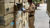 Lực lượng chức năng kiểm tra số lượng khẩu trang y tế không rõ nguồn gốc. Ảnh: Công an Hà Tĩnh cung cấp