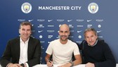 HLV Pep Guardiola (giữa) hài lòng trong buổi ký hợp đồng mới. Ảnh: The Sun