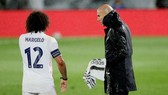 HLV Zinedine Zidane đội mưa sát cánh cùng các học trò. Ảnh: Getty Images