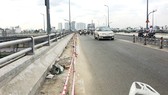 Phần lề đường dành cho người đi bộ trên cầu Nguyễn Tri Phương đang bị phá bỏ để mở rộng lòng đường, người đi bộ không còn lối đi qua cầu