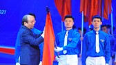 Thủ tướng Nguyễn Xuân Phúc gắn Huân chương Hồ Chí Minh lên cờ truyền thống của Trung ương Đoàn TNCS Hồ Chí Minh. Ảnh: TTXVN