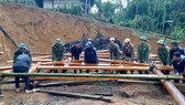 Cán bộ, chiến sĩ Đồn Biên phòng Tri Lễ tham gia dựng nhà mới cho gia đình bà Hà Thị Hoa (bản Cắm), là hộ nghèo, đơn thân
