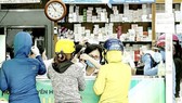 Người dân mua thuốc hỗ trợ điều trị Covid-19 tại một cửa hàng thuốc ở quận 4. Ảnh: HOÀNG HÙNG