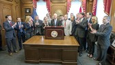 Thống đốc Rick Scott ký ban hành luật hạn chế súng tại Văn phòng Thống đốc ở Tallahassee, Florida, Mỹ, ngày 9-3-2018, dưới sự chứng kiến của các thành viên gia đình nạn nhân vụ xả súng trường học ở Parkland, Florida, Mỹ, ngày 14-2-2018. Ảnh: AP