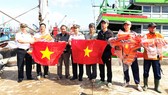 Vùng 4 Hải quân tặng cờ tổ quốc cho ngư dân Bình Định. Ảnh: NGỌC OAI
