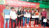Anh Liêu Ngọc Sơn (bìa phải), Bí thư Chi bộ, Chủ tịch Công đoàn Công ty TNHH thêu Vĩnh Dương (quận Tân Phú, TPHCM) trao giấy khen cho đoàn viên có thành tích tốt trong sản xuất