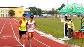Nhà vô địch Trần Văn Đảng (trái) hỗ trợ VĐV khiếm thị thi đấu ở Giải điền kinh khuyết tật quốc gia 2020. Ảnh: P.NGUYỄN