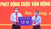 Ông Lê Văn Khanh, Chủ tịch Công ty XSKT Sóc Trăng (phải) trao 12 tỷ đồng hỗ trợ xây dựng nhà ở cho hộ nghèo