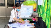 Cán bộ phường 4, quận 5 giải quyết chế độ chính sách hỗ trợ cho người dân. Ảnh: Cao Thăng