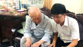 Ông Vĩnh Mẫn lật từng tấm ảnh kỷ niệm và kể về cuộc đời hoạt động cách mạng của mình với PV Báo SGGP