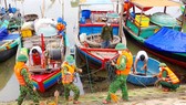 Bộ đội Biên phòng Hà Tĩnh giúp ngư dân neo đậu tàu thuyền. Ảnh: DƯƠNG QUANG