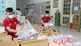 Cán bộ Quận đoàn quận 5 chuẩn bị gói an sinh trao tới người dân. Ảnh: HOÀNG HÙNG