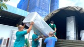 Nhân viên y tế Trung tâm Hồi sức Covid-19 do BV Bạch Mai quản lý đang vận chuyển đồ đạc trở về Hà Nội
