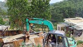 Cưỡng chế một căn nhà gỗ xây dựng theo kiểu biệt thự nhà vườn. Ảnh: TTXVN
