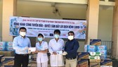 Giám đốc Trung tâm Báo chí và hợp tác truyền thông quốc tế tại TPHCM Lê Tự Phương Quang (trái) cùng mạnh thường quân trao quà hỗ trợ đội ngũ y, bác sĩ, các nhân viên y tế