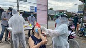 Nhân viên y tế lấy mẫu tầm soát Covid-19 cho người dân huyện Châu Thành, tỉnh Tây Ninh