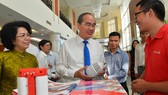 Bí thư Thành ủy TPHCM Nguyễn Thiện Nhân tìm hiểu sản phẩm thương hiệu Việt. Ảnh: VIỆT DŨNG