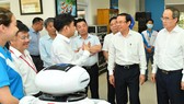 Bí thư Thành ủy TPHCM Nguyễn Văn Nên và đồng chí Nguyễn Thiện Nhân tìm hiểu hoạt động của công ty tại CVPM Quang Trung. Ảnh: VIỆT DŨNG