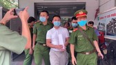 Ông Tùng (áo trắng) bị công an bắt giữ
