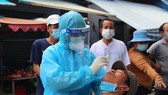 Lấy mẫu xét nghiệm Covid-19 của người dân ở quận Bình Tân. Ảnh: CHÍ THẠCH