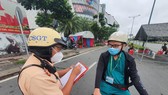 Lực lượng chức năng kiểm tra người dân tham gia lưu thông trên đường. Ảnh: CHÍ THẠCH