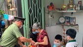 Thiếu tướng Cao Đăng Hưng trao quà tận tay người dân có hoàn cảnh khó khăn ở phường 8, quận 4, TPHCM. Ảnh: CHÍ THẠCH