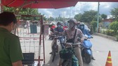 Kiểm tra người dân lưu thông qua chốt kiểm soát chân cầu Him Lam, quận 7 vào chiều ngày 15-9. Ảnh: CHÍ THẠCH