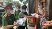 Thượng Tá Trần Anh Thanh, Phó Trưởng Phòng PX03, Công an TPHCM cùng Thượng tá Huỳnh Trung Phong, Trưởng Công an quận 6 gõ cửa nhà dân trao các phần quà hỗ trợ. Ảnh: CHÍ THẠCH