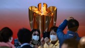 Nhiều du khách đeo khẩu trang vẫn đến thăm đài lửa Olympic Tokyo
