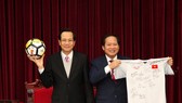 Bộ trưởng Bộ LĐ-TB&XH Đào Ngọc Dung (trái) và Bộ trưởng Bộ Thông tin và Truyền thông Trương Minh Tuấn nhận trái bóng, chiếc áo đấu của U23 Việt Nam tặng Thủ tướng Chính phủ để chuẩn bị đấu giá. Nguồn: VGP