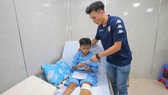 Thủ môn Bùi Tiến Dũng tặng quà cho các em học sinh trường THCS Bạch Đằng trong vụ cây phượng bật gốc. Ảnh: Dũng Phương