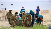 Lực lượng chức năng hỗ trợ ngư dân đưa thuyền thúng lên bờ