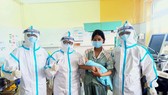 Chị M. lưu giữ tấm hình kỷ niệm với đội ngũ bác sĩ cứu sống chị cùng con trai. Ảnh: Bệnh viện dã chiến Hòa Vang